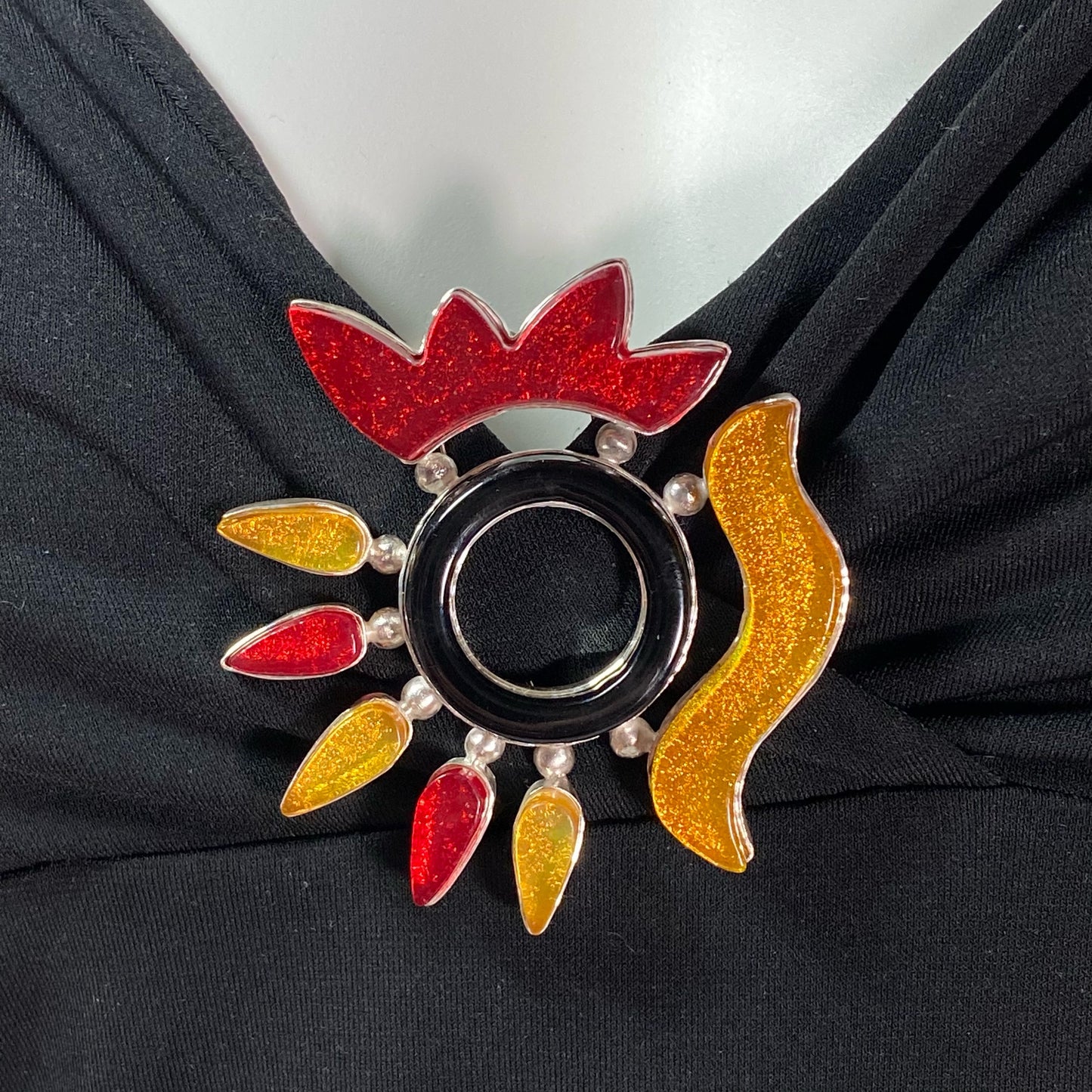 hand cut yellow and red abstract elements and water jet black glass circle brooch, fused glass, glass jewelry, glass and silver jewelry, handmade, handcrafted, American Craft, hand fabricated jewelry, hand fabricated jewellery, Athen, Georgia, colorful jewelry, sparkle, bullseye glass, dichroic glass, art jewelry