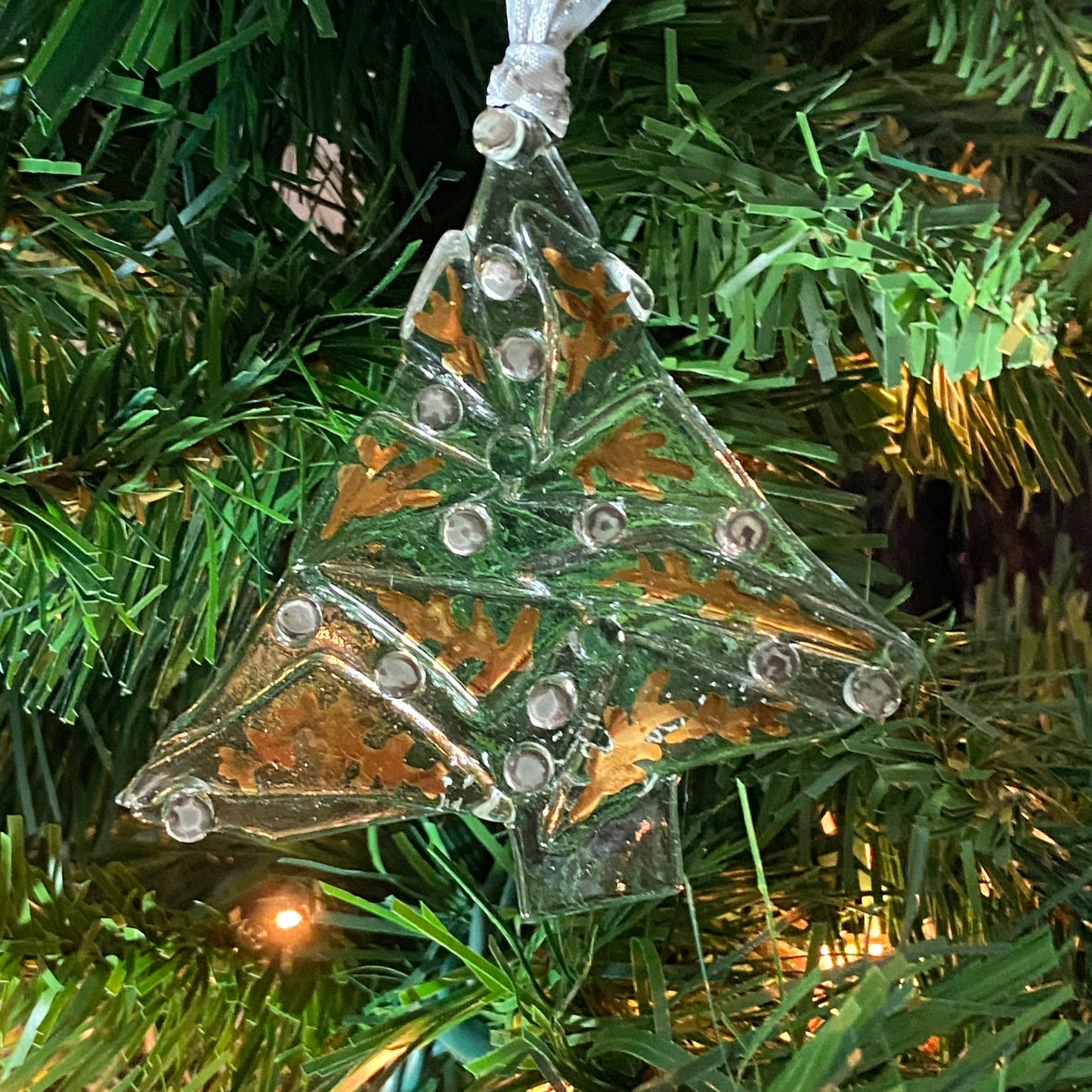 single 3 1/2 inches wide by 3 1/4 inch tall abstract clear tree ornament with fired on gold luster leaves and silver luster balls 