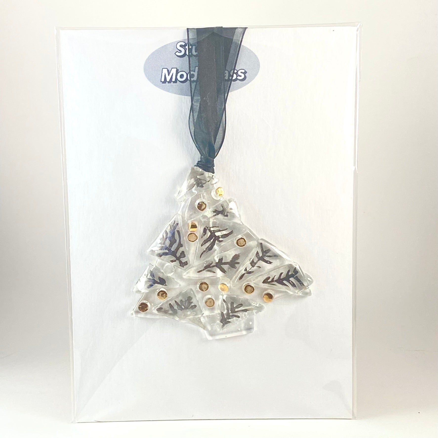 shown in gift packaging is the single 3 1/2 inches wide by 3 1/4 inch tall abstract clear tree ornament with silver luster leaves and gold luster balls fired on