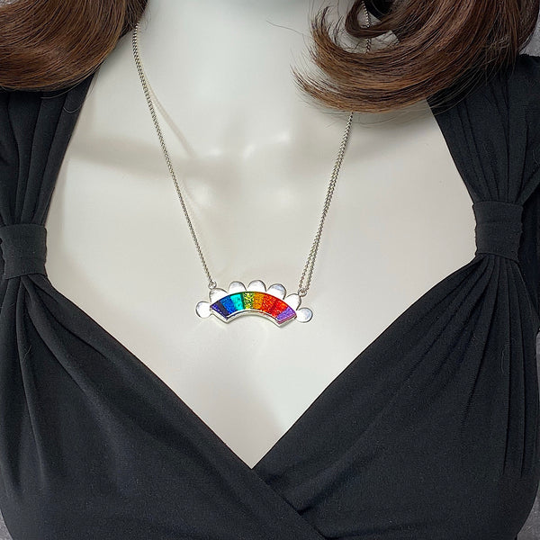 rainbow colored glass hand cut rainbow shape with silver flange cut out clouds necklace, fused glass, glass jewelry, glass and silver jewelry, handmade, handcrafted, American Craft, hand fabricated jewelry, hand fabricated jewellery, Athen, Georgia, colorful jewelry, sparkle, bullseye glass, dichroic glass, art jewelry