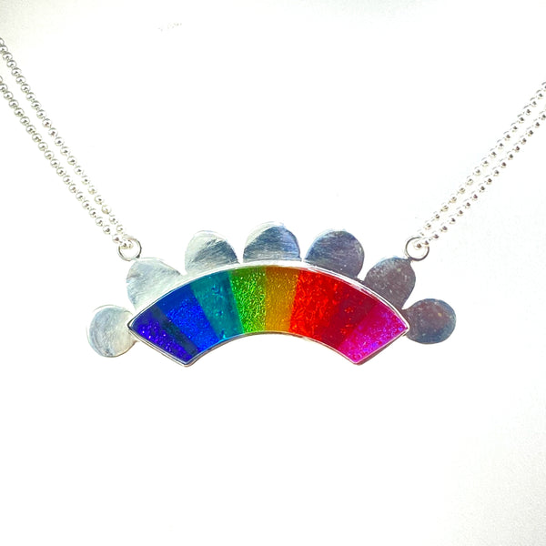rainbow colored glass hand cut rainbow shape with silver flange cut out clouds necklace, fused glass, glass jewelry, glass and silver jewelry, handmade, handcrafted, American Craft, hand fabricated jewelry, hand fabricated jewellery, Athen, Georgia, colorful jewelry, sparkle, bullseye glass, dichroic glass, art jewelry