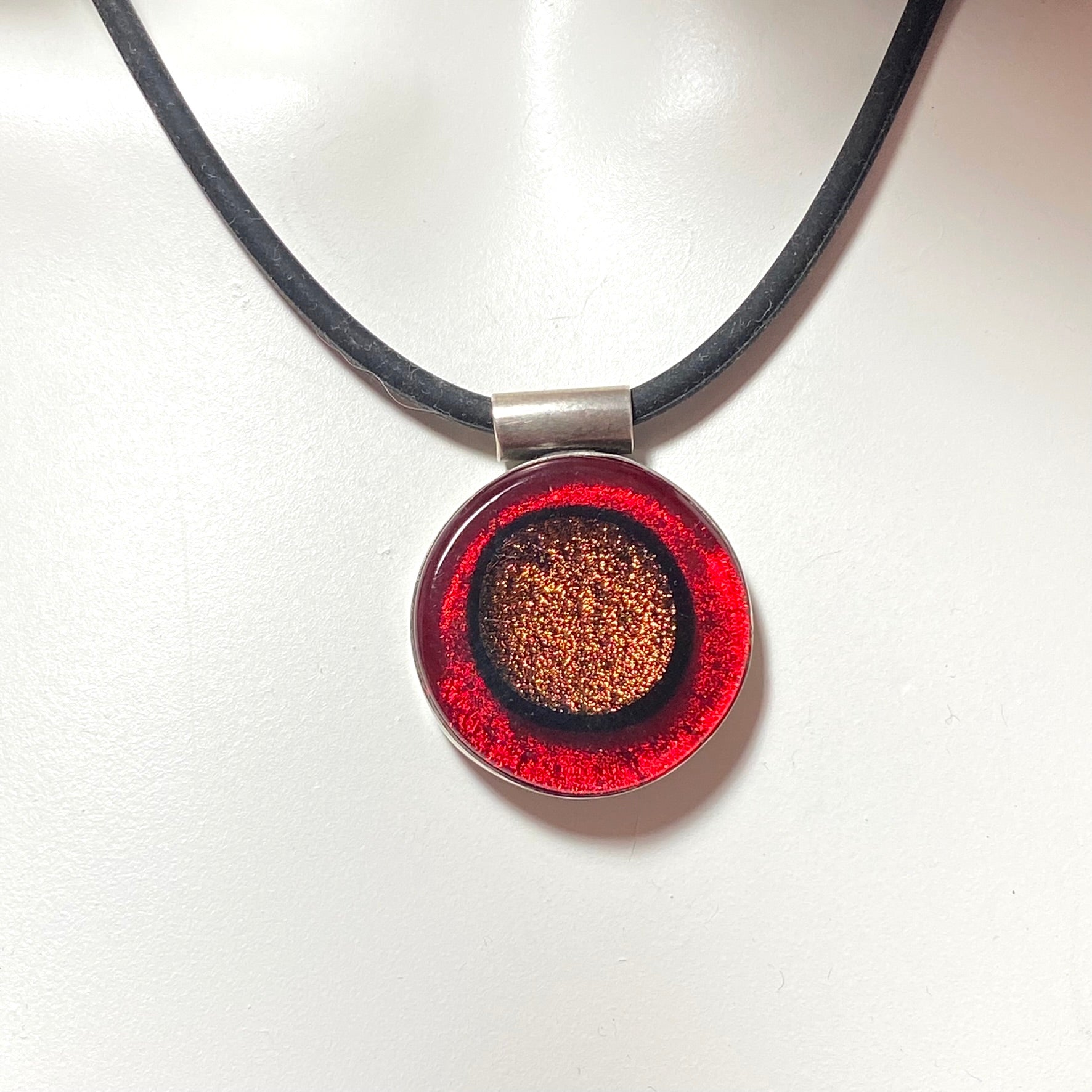 Circle pendant with copper and red colored glass in sterling silver, fused glass, glass jewelry, glass and silver jewelry, handmade, handcrafted, American Craft, hand fabricated jewelry, hand fabricated jewellery, Athen, Georgia, colorful jewelry, sparkle, bullseye glass, dichroic glass, art jewelry