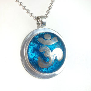 Namaste painted silver luster over blue necklace, fused glass, glass jewelry, glass and silver jewelry, handmade, handcrafted, American Craft, hand fabricated jewelry, hand fabricated jewellery, Athen, Georgia, colorful jewelry, sparkle, bullseye glass, dichroic glass, art jewelry